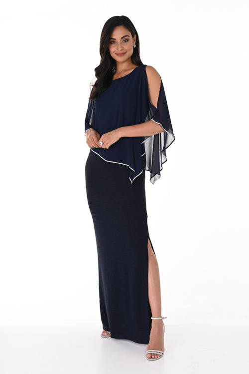 Woman wearing a long navy dress with white accents on a white background