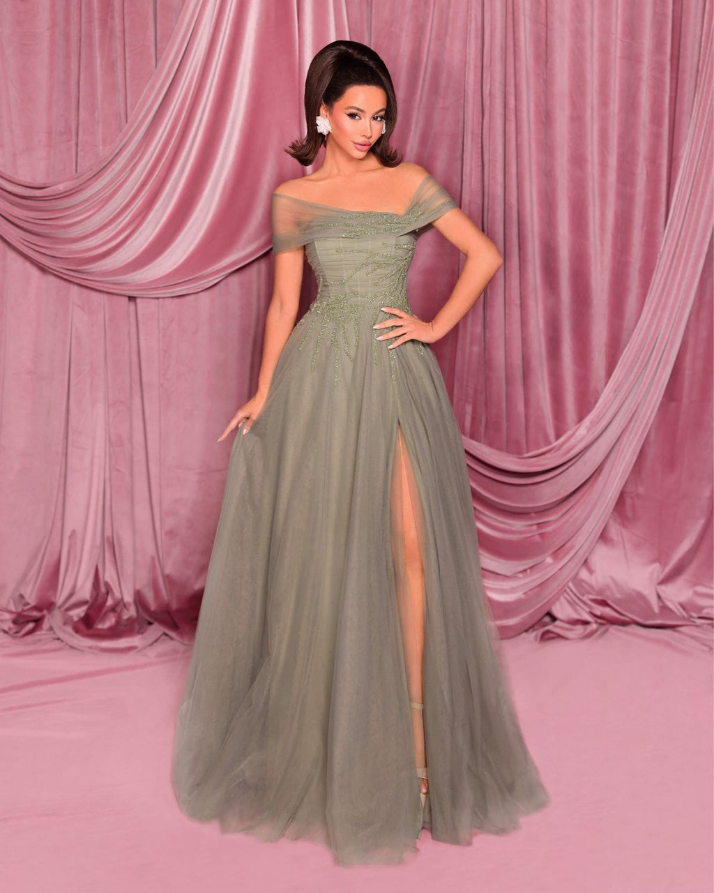 Woman in a green evening gown with a pink curtain backdrop