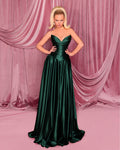 Woman in a green evening gown against a pink curtain backdrop