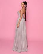Woman in a silver evening gown against a pink background