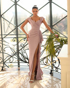 Woman in a pink evening gown standing in a stylish interior setting