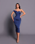 Woman wearing a blue off-shoulder dress against a gray background