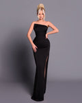 Woman wearing a black strapless gown against a gray background