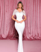 Woman wearing a white lace dress against a pink curtain background