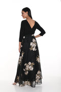 Woman wearing a black dress with floral patterns on a white background
