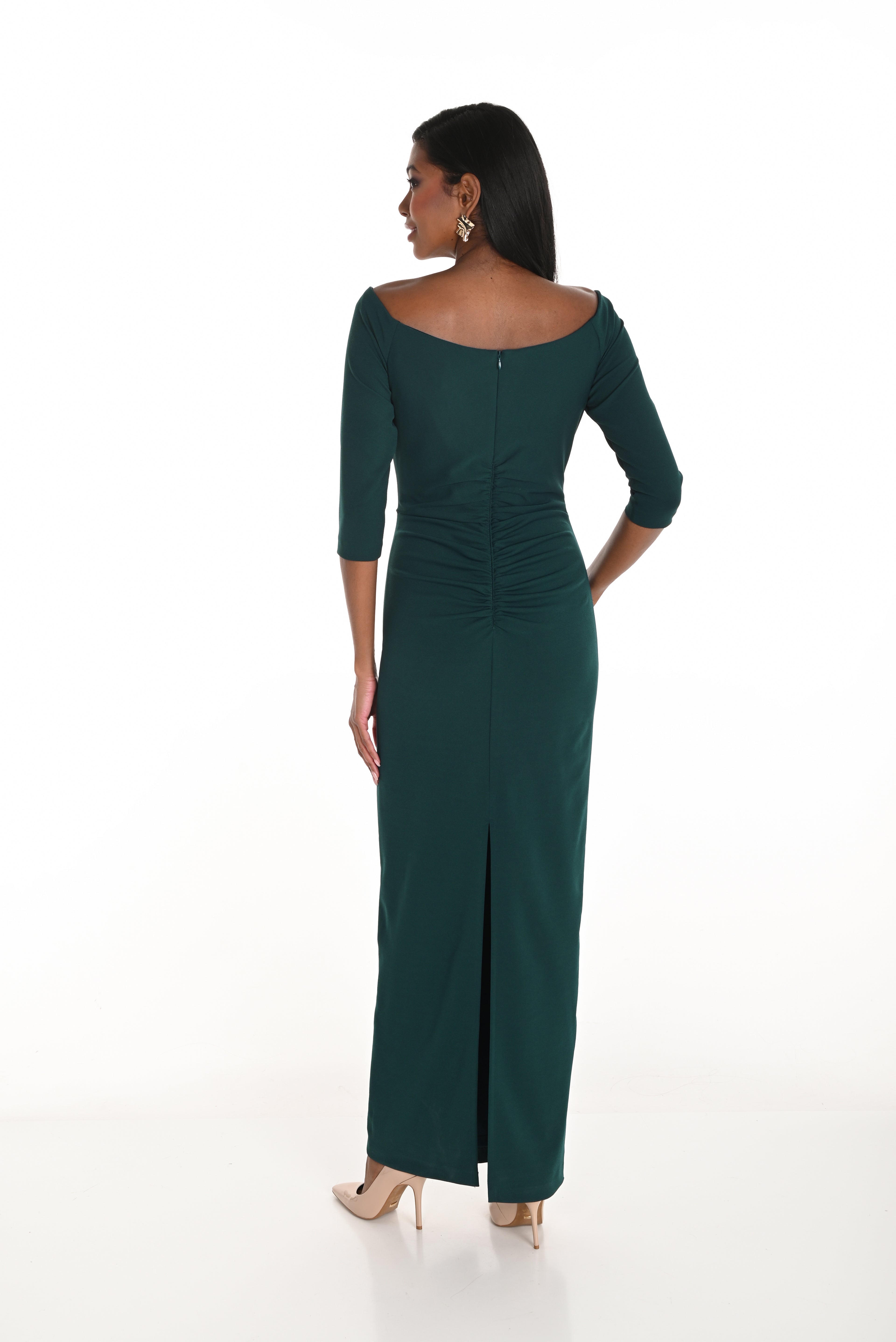 Woman wearing a green dress with a slit on a white background