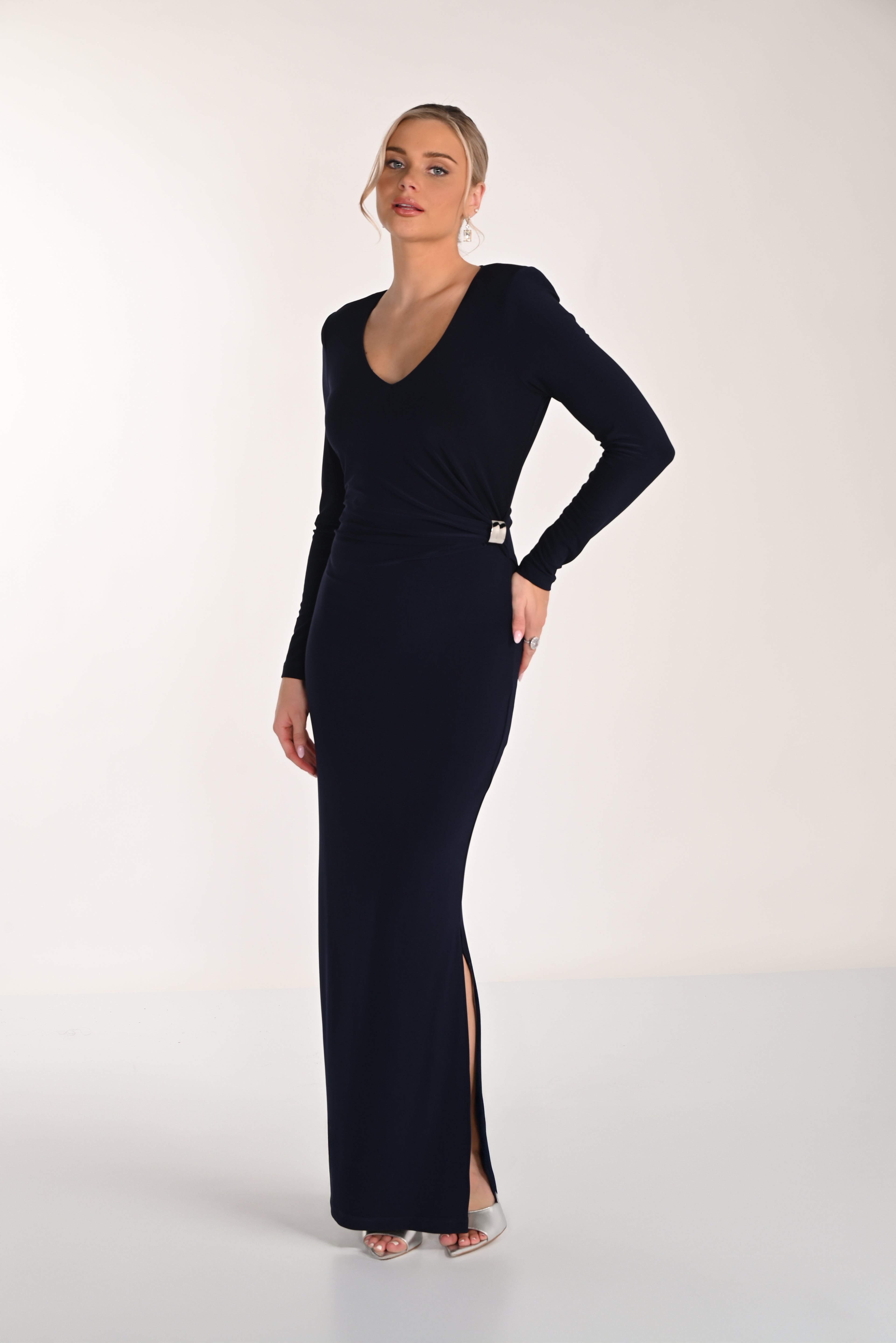 Woman wearing a black long-sleeve gown with a slit on a white background