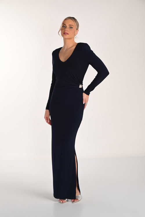 Woman wearing a black long-sleeve gown with a slit on a white background
