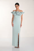 Woman wearing a light blue evening gown with floral details on a white background