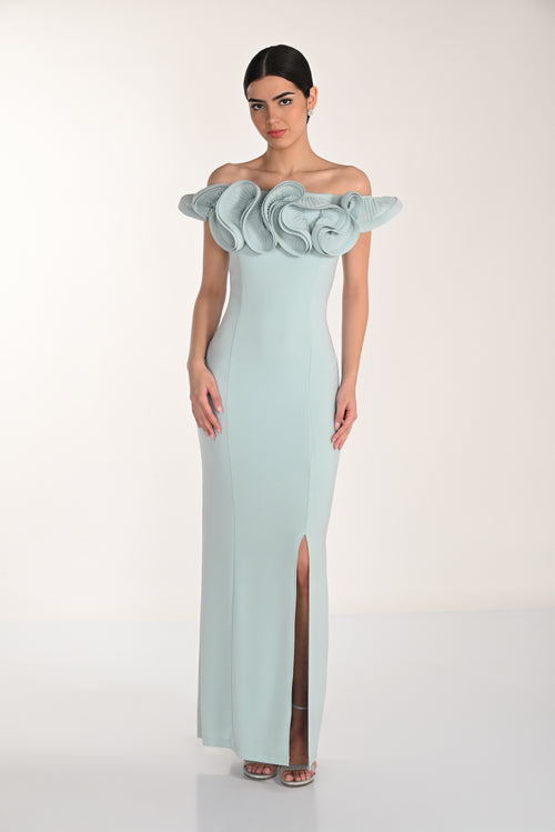 Woman wearing a light blue evening gown with floral details on a white background