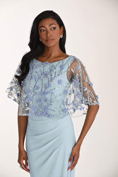 Woman wearing a light blue dress with floral embellishments on a white background