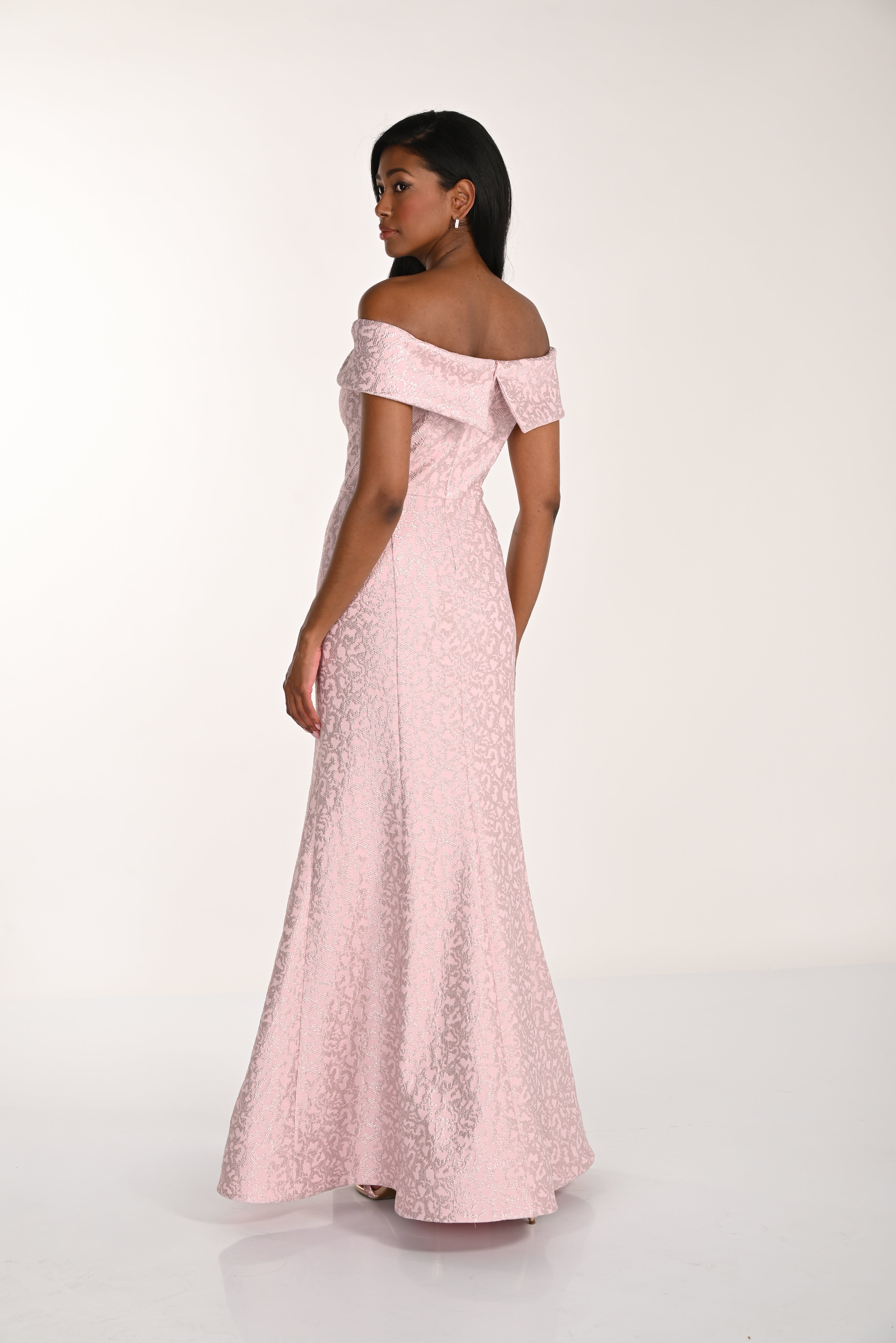Woman wearing a pink off-shoulder dress against a white background