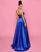 Woman wearing a blue strapless gown against a pink background