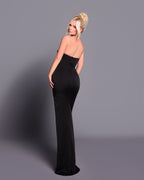Woman wearing a black strapless gown against a gray background