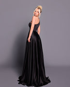 Woman wearing a black evening gown against a gray background