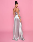 Woman wearing a silver strapless gown against a pink background