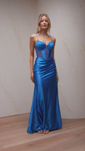 Woman wearing a blue evening gown against a neutral background