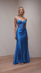 Woman wearing a blue evening gown against a neutral background