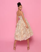 Woman wearing a floral dress against a pink background