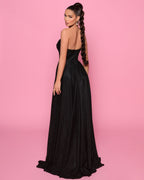 Woman in a black evening gown against a pink background