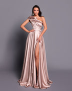 Woman wearing a long, elegant dress with a slit on a gray background