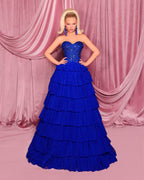 Woman wearing a blue evening gown with a pink curtain background