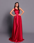 Woman wearing a red satin gown against a gray background