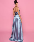 Woman wearing a strapless silver gown against a pink background