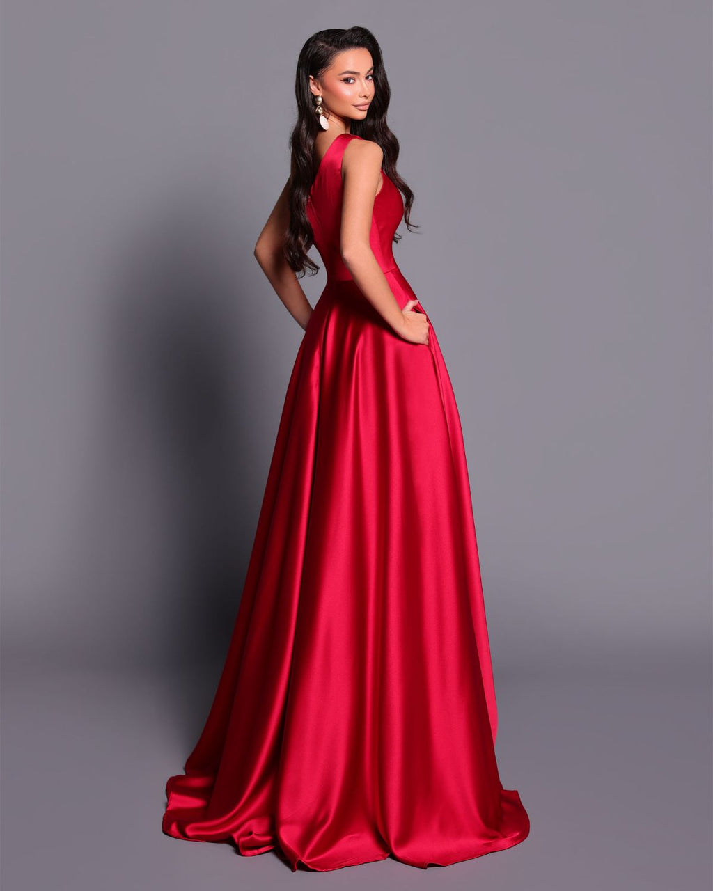 Woman wearing a red evening gown against a gray background