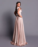 Woman wearing a long, elegant dress with a plain background