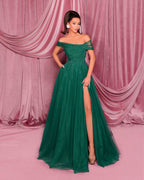 Woman in a green evening gown with a pink curtain backdrop
