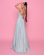Woman in a silver evening gown against a pink background