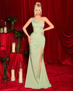 Woman in a green one-shoulder dress standing against a red curtain backdrop.