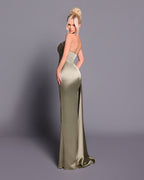 Woman wearing a long, elegant green dress against a gray background