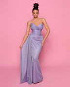 Woman wearing a strapless purple gown against a pink background