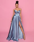 Woman wearing a strapless metallic gown with a high slit on a pink background