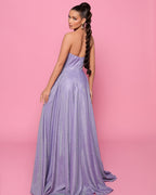 Woman in a strapless purple gown against a pink background