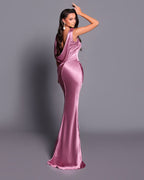 Woman wearing a pink satin gown against a gray background