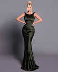 Woman wearing a green evening gown against a gray background