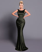 Woman wearing a green evening gown against a gray background