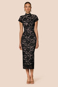 Woman wearing a dark lace dress on a beige background