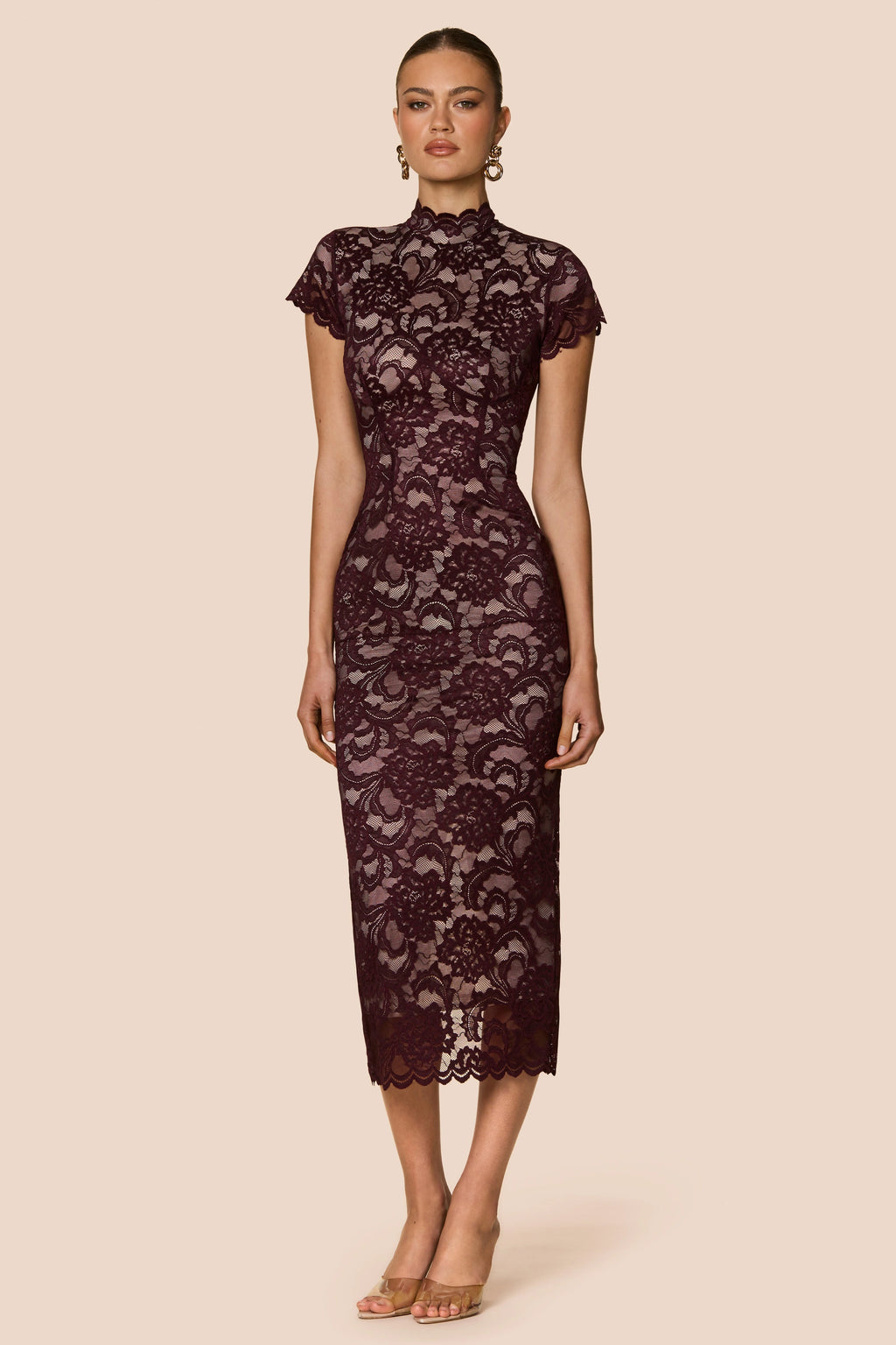 Woman wearing a dark lace dress on a beige background