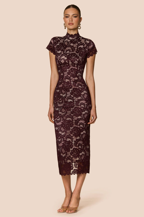 Woman wearing a dark lace dress on a beige background