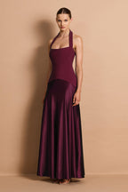 Woman wearing a burgundy halter neck gown against a beige background