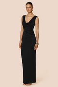 Woman wearing a black evening gown on a beige background