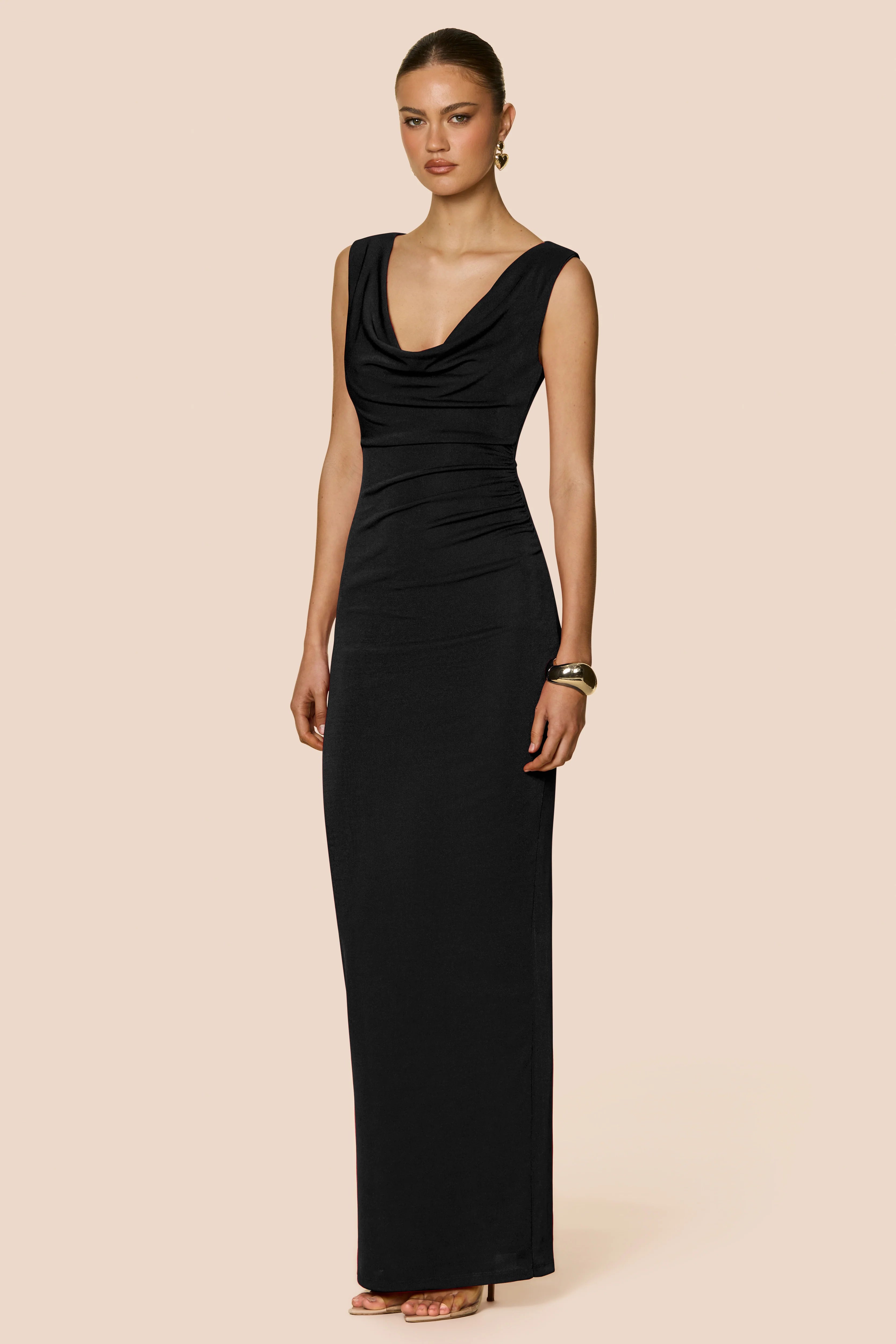 Woman wearing a black evening gown on a beige background