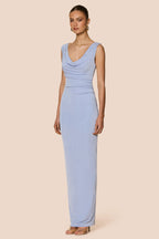 Woman wearing a light blue dress against a beige background