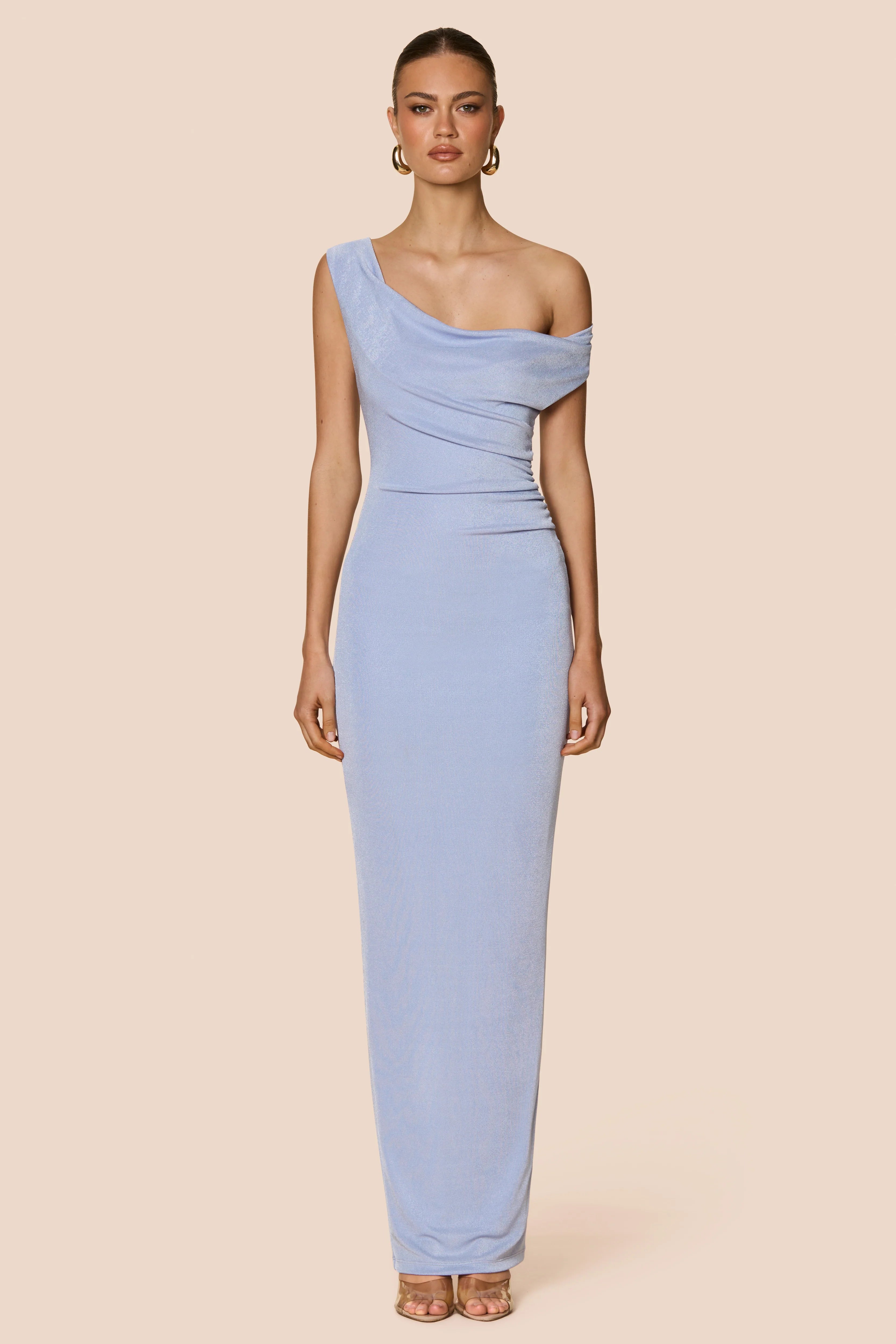 Woman wearing a light blue one-shoulder dress on a beige background