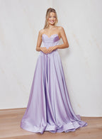 Woman wearing a strapless lavender gown against a plain background