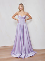 Woman wearing a strapless lavender gown against a plain background
